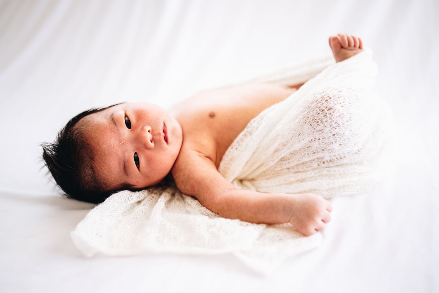 newborn baby looking at the camera in a newborn and family photoshoot in Melbourne by Melbourne Maternity, newborn and family photographer.