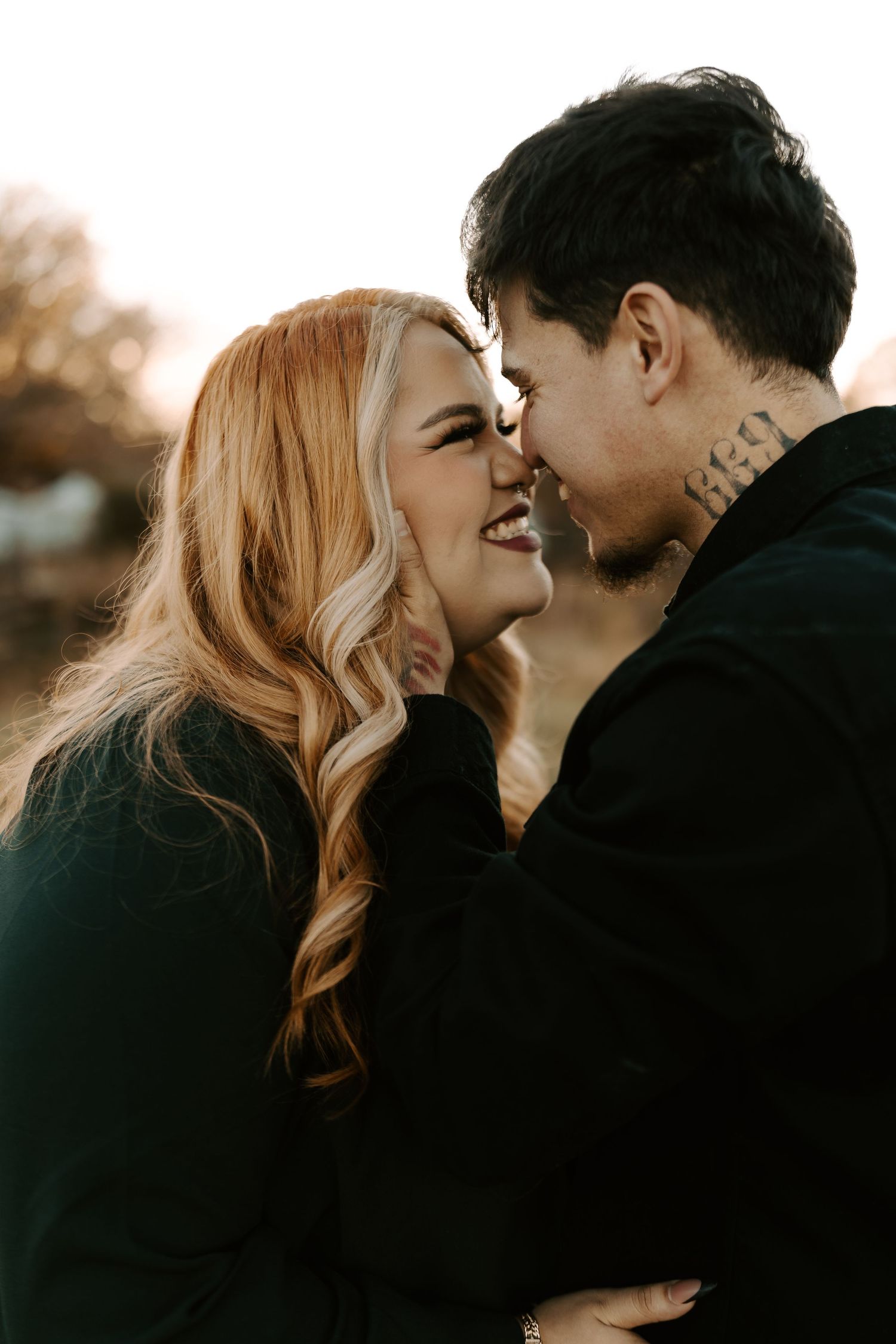 Intimate couple sharing tender moments in warm autumn sunlight.