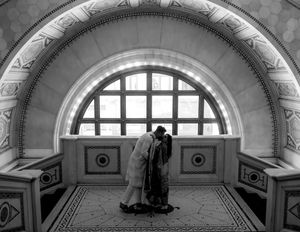 Black and white architectural detail of arched windows and decorative ceiling.