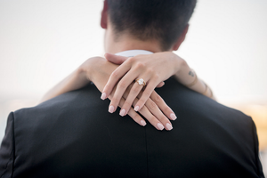 Close-up details of hands and shoulders in black and white tones.