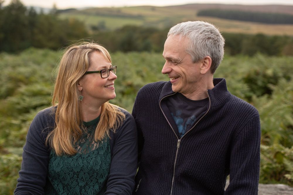 A couple sharing a joyful moment together in an outdoor natural setting.