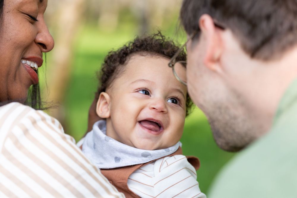 Heartwarming close-up of joyful family moment with baby laughing.