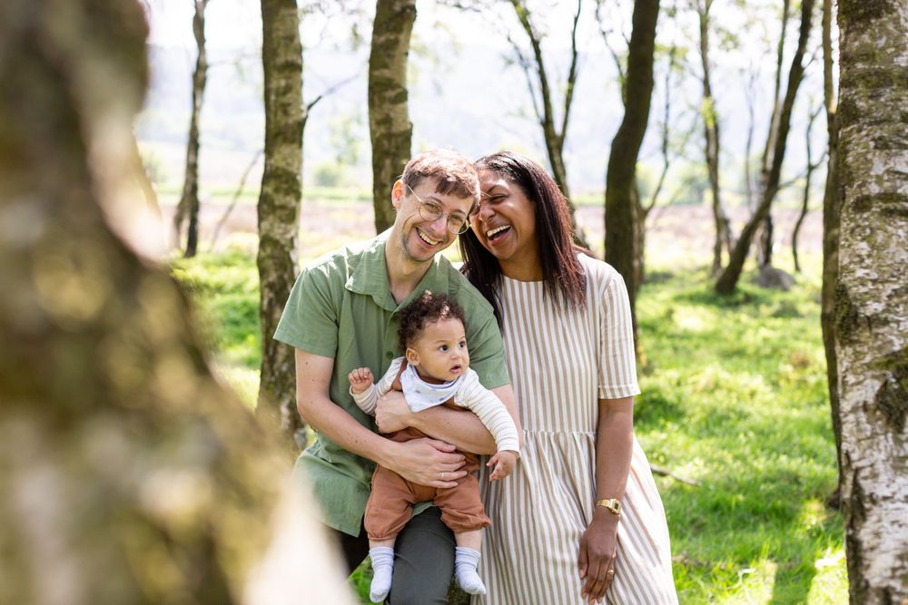 Natural outdoor family portrait among birch trees in spring.
