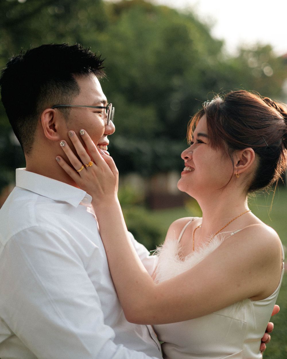 Intimate moment between couple in wedding attire during outdoor photoshoot.