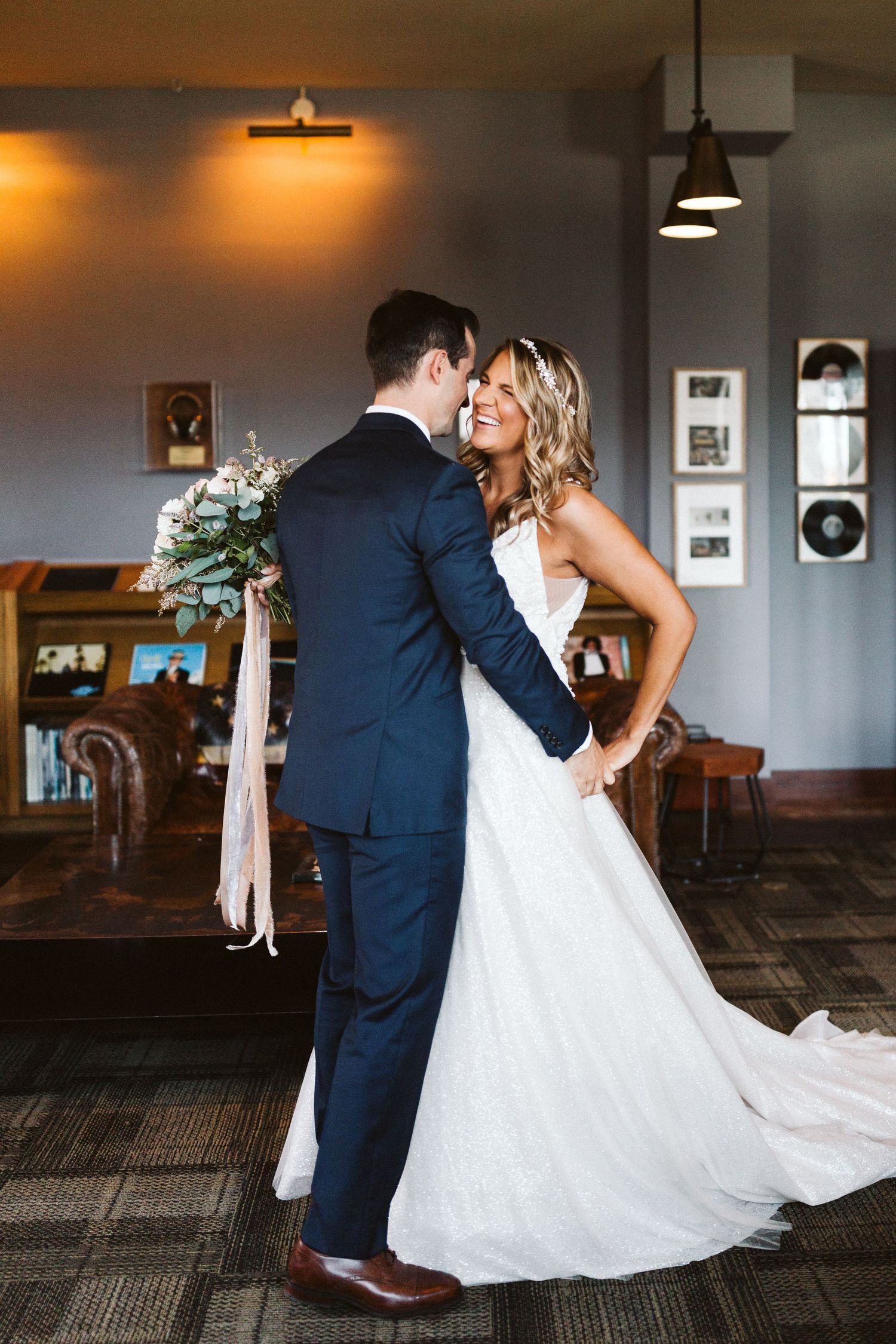 A couple dances together in an indoor venue with warm lighting and carpeted floors.