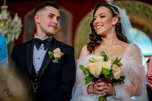 Romantic wedding ceremony moments in warm-toned venue lighting.