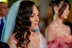 Wedding attendees in formal wear with elegant hairstyles and makeup during the ceremony.