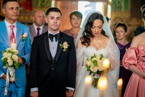 Wedding ceremony in progress with formal attire and yellow floral arrangements.