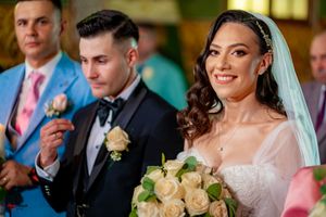 Wedding ceremony attendees gathered in an elegant indoor venue with warm lighting and floral decorations.