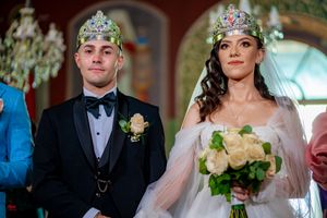 Wedding ceremony participants stand together in an elegantly decorated venue with warm lighting.