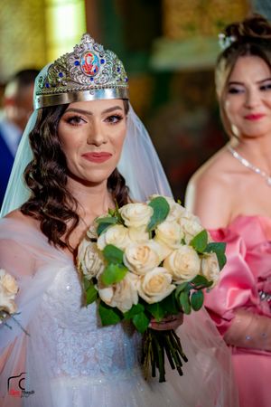 Close-up of bridal details featuring crown, veil, and cream rose bouquet.