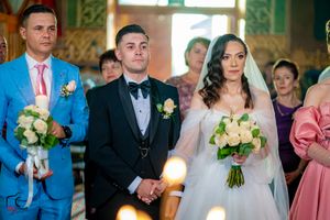 Wedding celebration scene with guests and wedding party in a decorated church venue.