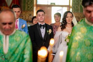 Wedding ceremony participants stand in a row with decorative green lighting in the background.