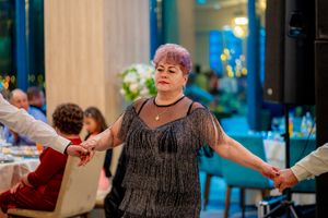 Group dancing at formal event with decorative lighting and elegant atmosphere.