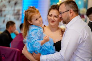 Dancing couples enjoying themselves at a formal celebration with blue ambient lighting.