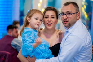 Couples dancing together at an elegant event with blue lighting and festive atmosphere.