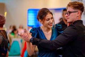 Dance partners gracefully moving together during an indoor social gathering.