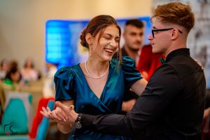 Couples enjoying a formal dance with blue accent lighting in the background.