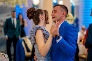 Formal dance partners gliding across the floor at an elegant indoor celebration.