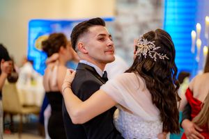 Couples dancing at a wedding celebration with elegant lighting and decor.
