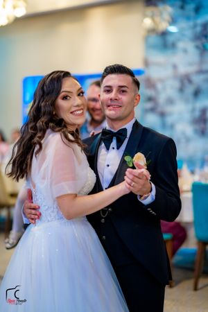 Wedding celebration on dance floor with romantic lighting and formal attire.