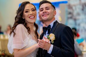 Couples dancing and celebrating at wedding reception with blue accent lighting.