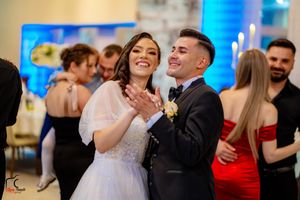 Wedding party dancing and celebrating with blue mood lighting and formal decor.