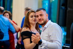 Guests dancing at formal event with vibrant lighting and festive atmosphere.