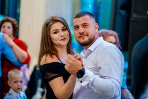 Couples dancing together at an elegant event with blue lighting and formal attire.