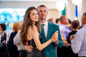 Couples dancing together at a formal celebration with ambient lighting.