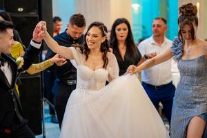 Wedding reception dance floor filled with guests in elegant attire.