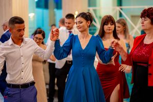 Guests dancing in colorful formal wear at an elegant indoor celebration.
