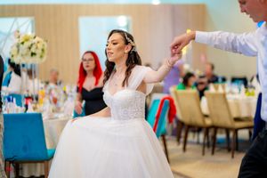 Elegant wedding reception with guests dancing in formal attire under soft lighting.