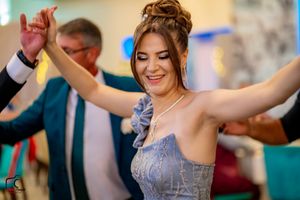 Dancers in formal attire move in synchronized steps at an elegant indoor venue.