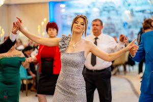 Guests in evening wear dance together under soft lighting at a formal celebration.