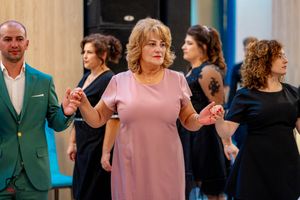 Party guests in formal attire dance together at an elegant indoor celebration.