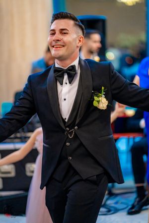 Dancer in classic black tuxedo and bowtie performs at formal celebration.
