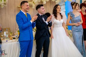 Wedding reception dance floor filled with guests in formal attire celebrating beneath floral decor.
