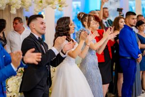 Festive wedding reception with guests enjoying themselves under elegant floral decor.