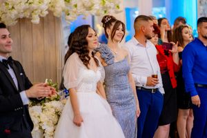 Wedding celebration with guests dancing and enjoying festivities in an elegantly decorated venue.