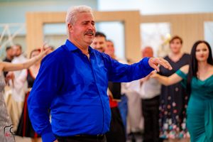 Dancer in bright blue shirt performs traditional moves at a festive celebration.