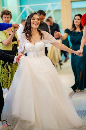 Bride dancing in white ballgown during wedding celebration.