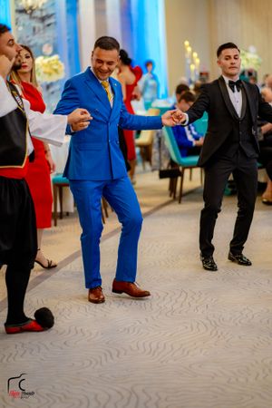 Wedding guests perform a synchronized dance routine on a carpeted ballroom floor.
