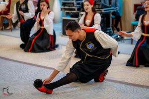 Dancers in black and red costumes perform a coordinated routine at a wedding reception.