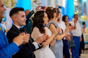 Wedding guests and performers dance together during a lively celebration.