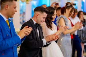 Guests and performers celebrate with enthusiastic dancing at an indoor event.