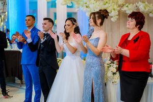 Wedding party and guests celebrating with applause in an elegantly decorated venue.