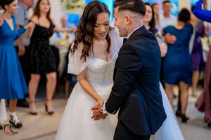 Couples dancing together at an elegant wedding reception with decorative lighting.