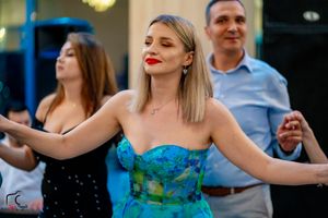Dancer in blue strapless gown performs with group at elegant indoor venue.