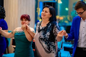 Dancers in formal wear moving in synchronized steps during a ballroom dance event.